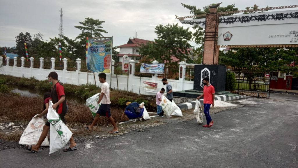 Mahasiswa bergotong-royong membersihkan sampah plastik di lingkungan kampus memperingati Hari Anti Narkotika Internasional