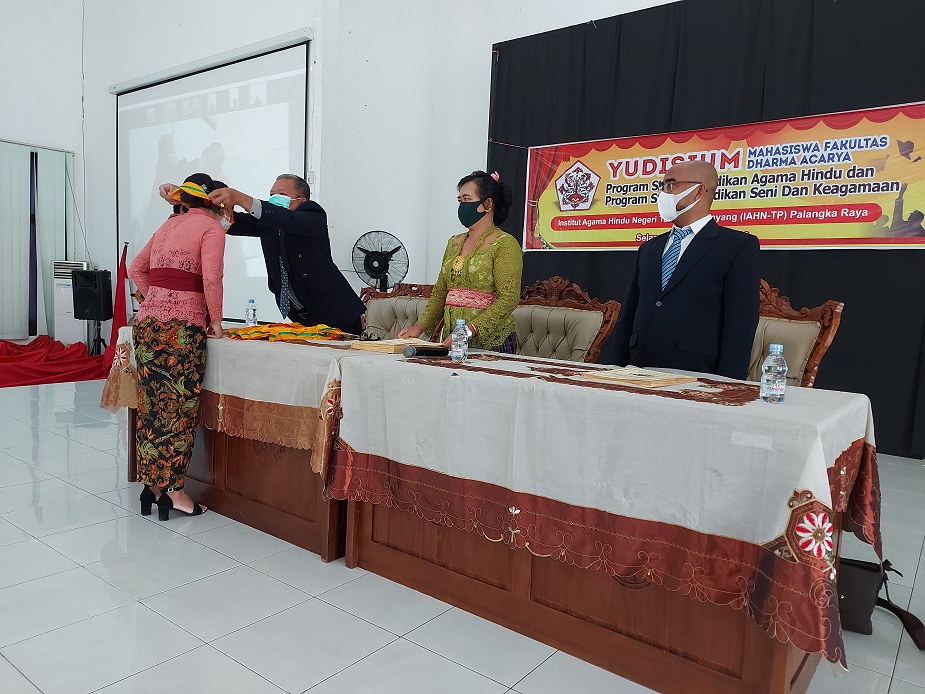 Pengalungan Medali oleh Dekan Fakultas Dharma Acarya (kiri) didampingi Kapodi Pendidikan Agama Hindu (tengah) dan Kaprodi Pendidikan Seni dan Keagamaan (Kanan)